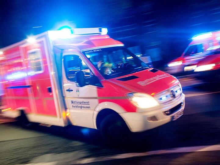 Ein Rettungswagen fährt mit Blaulicht durch eine Straße. Foto: picture alliance/Marcel Kusch/dpa/Illustration