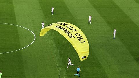 Ein Greenpeace-Aktivist landet auf dem Spielfeld.
