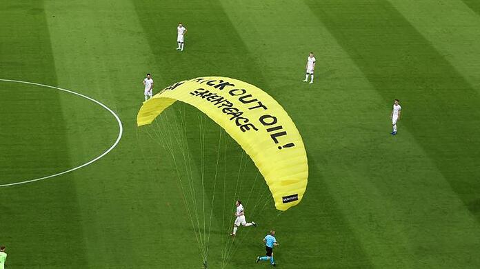 Ein Greenpeace-Aktivist landet auf dem Spielfeld.