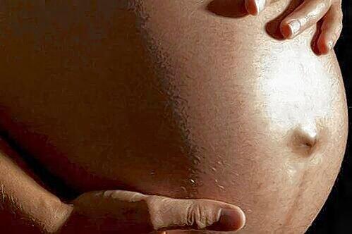 Eine Hochschwangere hält ihren schweren Bauch.