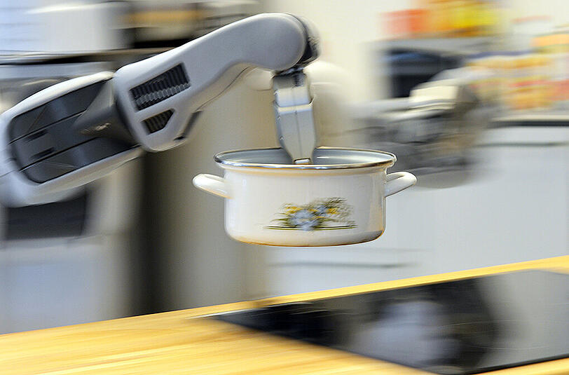 Der Roboter "PR2" stellt in einer Laborküche des Institute for Artificial Intelligence (IAI) am Technologie-Zentrum Informatik (TZI) der Universität Bremen einen Topf auf den Herd. Der Roboter kann experimentell selbstständig Aufgaben im Haushalt übernehmen und ist Teil eines europaweiten Projekts.