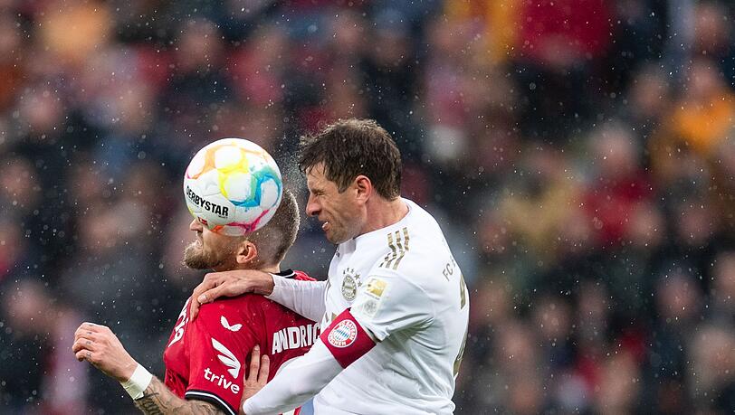 Bayerns Thomas Müller (r) und Leverkusens Robert Andrich kämpfen um den Ball.