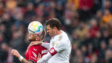 Bayerns Thomas Müller (r) und Leverkusens Robert Andrich kämpfen um den Ball.