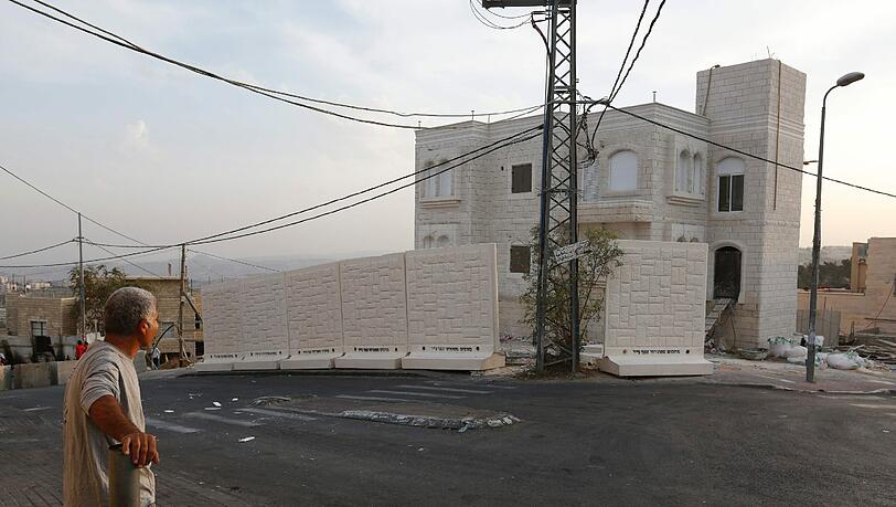 Ein Palästinenser schaut zu einer Mauer, errichtet von israelischen Streitkräften in Ost-Jerusalem nahe des arabischen Viertels Jabel Mukaber. Ein Palästinenser schaut zu einer Mauer, errichtet von israelischen Streitkräften in Ost-Jerusalem nahe des arabischen Viertels Jabel Mukaber.