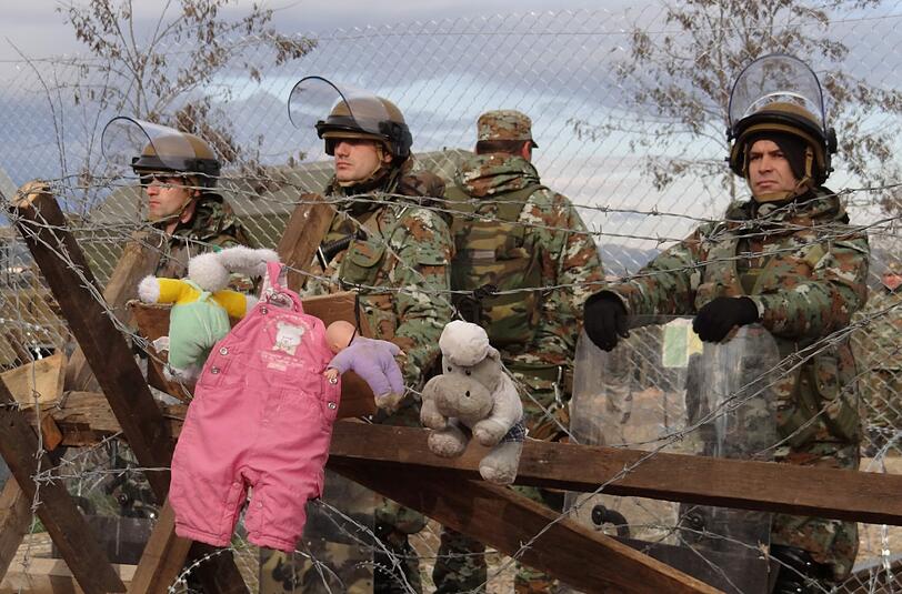 Mazedonische Soldaten bewachen die Grenze. Auf der griechischen Seite haben Flüchtlinge Stofftiere an den Zaun gehängt.