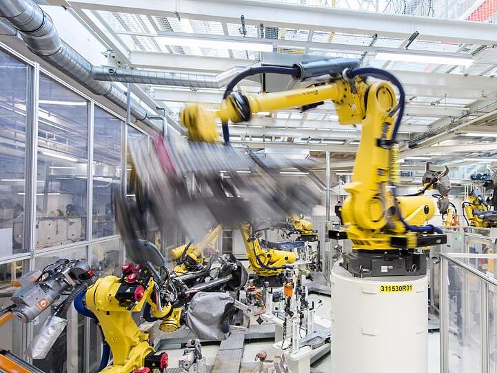 In der deutschen Industrie scheint es wieder aufwärts zu gehen: Industrieroboter schweißen in einer Volkswagen Autofabrik Teile an.