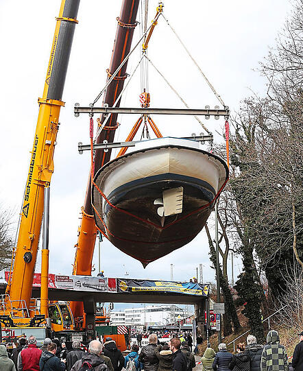 Schaulustige aus dem Viertel und Pressevertreter aus ganz Deutschland verfolgen, wie die Utting auf die Eisenbahnbrücke gehoben wird.