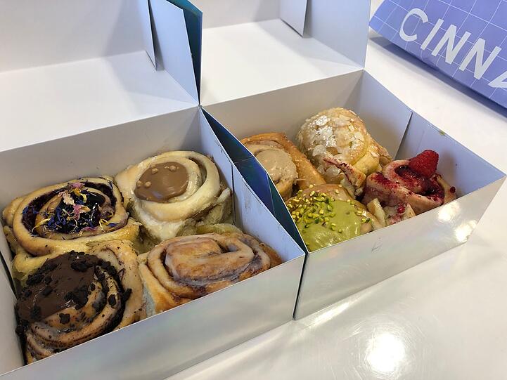 Acht Zimtschnecken, unter anderem mit Pistazie-, Oreo- und Himbeer-Geschmack.