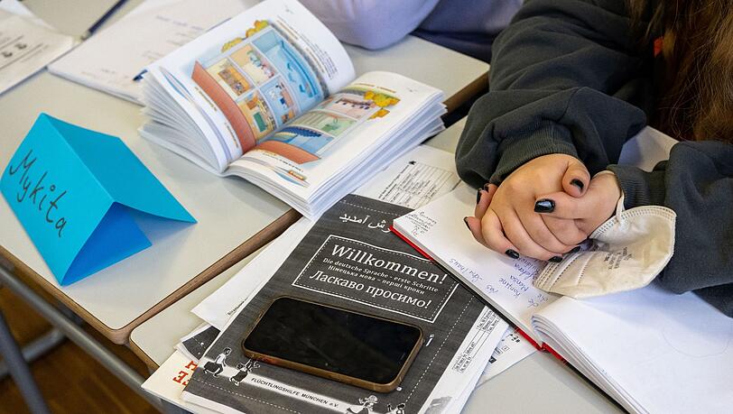 Ein Mädchen aus der Ukraine sitzt mit ihrem Unterrichtsmaterial in einer Klasse.