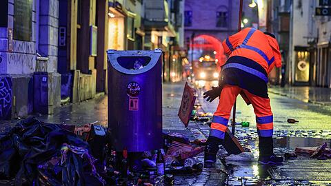 Wo gefeiert wird, fällt Müll an: Mitarbeiter der Straßenreinigung fegen in der Nacht in Köln den Abfall zusammen.