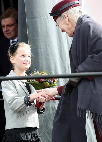 Ein Mädchen überreicht der dänischen Königin Margrethe II. am 18.04.2014 in Sonderburg (Dänemark) während einer Gedenkfeier zum 150. Jahrestag der Schlacht bei den Düppeler Schanzen einen Blumenstrauß.