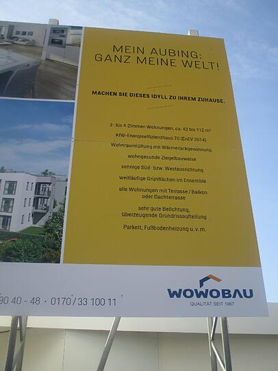 Neue Wohnungen für Aubings Osten: Eine Werbetafel am Baustelleneingang.