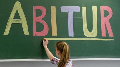Eine Schülerin unterstreicht das Wort "Abitur" an der Tafel. Foto: picture alliance / dpa/Symbolbild
