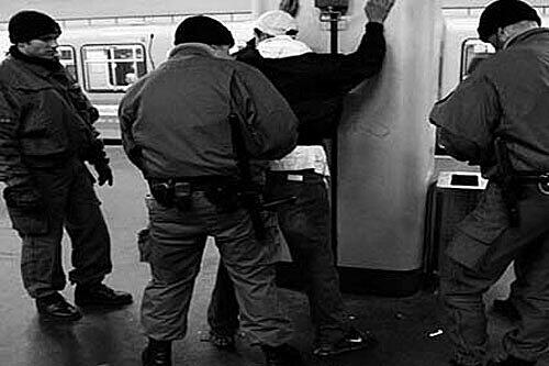Die Polizei durcuscht einen jungen Mann in der U-Bahn