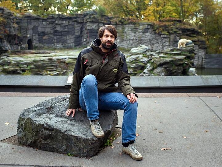 Florian Sicks, Säugetier-Kurator im Tierpark Berlin, sitzt vor dem Eisbären-Gehege.
