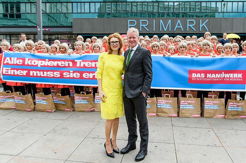Aktion gegen Billigmode: 150 Kleidungs-Klone versammelten sich am Mittwochmorgen auf dem Alexanderplatz. (V.l.): Inge Szoltysik-Sparrer (TV-Serie "Geschickt eingefädelt") und Holger Schwannecke, Generalsekretär des Zentralverbands des Deutschen Handwerks.