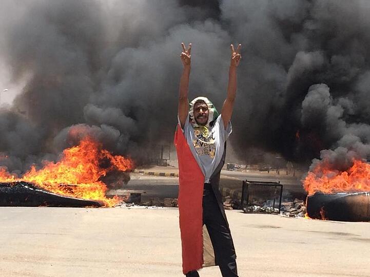Ein Demonstrant steht in der Nähe des Armeehauptquartiers in der sudanesischen Hauptstadt Khartum vor brennenden Barrikaden.