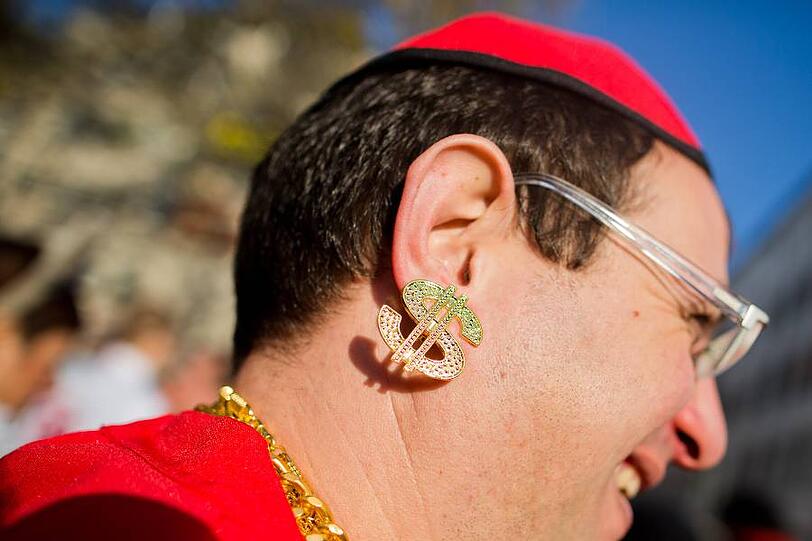 Im Ohr das Dollarzeichen - der limburger Bischof geriet vor einigen Wochen vor allem wegen seiner Verschwendungssucht in die Kritik. Jetzt muss seine Affäre im Fasching herhalten.