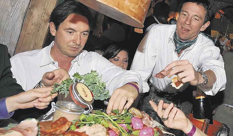 Schmankerl-Sause: Martin Bachmann (Columbia TriStar) und Produzent Oliver Berben (r.) stärken sich. Was auf keinem Tisch fehlen darf: eine Riesen-Flasche Champagner (r.).
