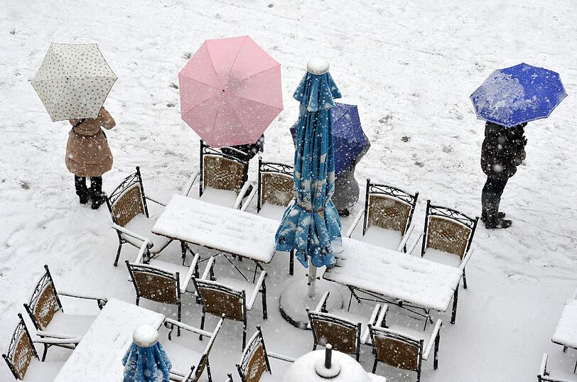 Dieses Straßencafé auf dem Marienplatz hat die Tische und Stühle trotz Wintereinbruchs draußen stehen lassen.