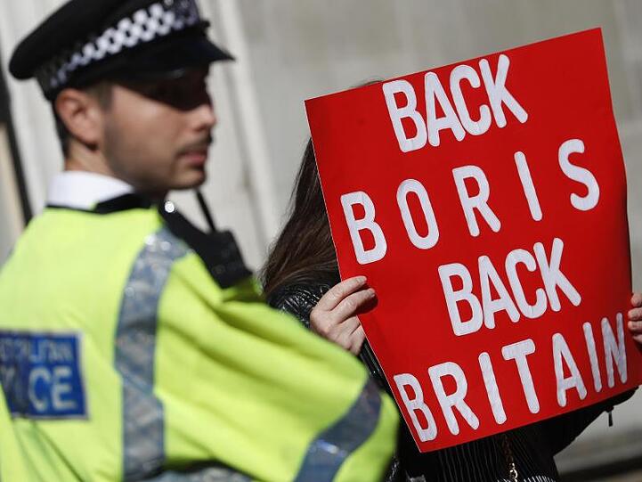 Ein Polizist steht neben einem Pro-Brexit-Demonstranten in London. Premier Boris Johnson will vor allem eine Änderung beim Backstop erreichen.
