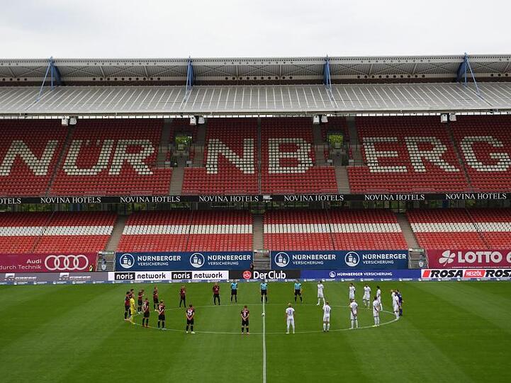 Die Spieler halten eine Schweigeminute zum Gedenken an die Opfer der Coronavirus-Pandemie. Foto: Matthias Hangst/Getty Images Europe/Pool/dpa