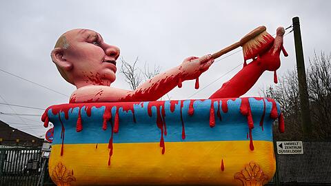 Ein Mottowagen in Düsseldorf zeigt den  russischen Präsidenten, der in einer Badewanne in den ukrainischen Nationalfarben ein "Blutbad" nimmt.