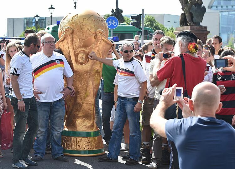 Die Fans warteten gespannt auf das Team. Diese hier hatten einen überdimensionalen Weltpokal dabei.