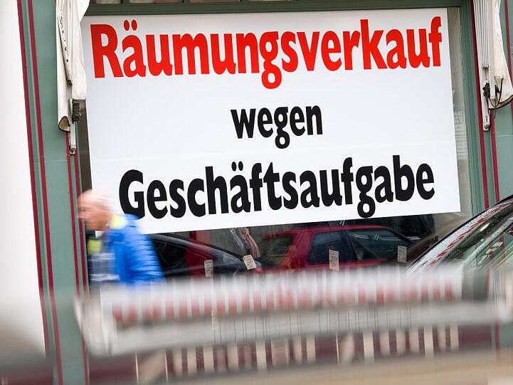 Ein Schild mit der Aufschrift "Räumungsverkauf wegen Geschäftsaufgabe" hängt im Schaufenster eines Ladengeschäfts in der Münchener Innenstadt.