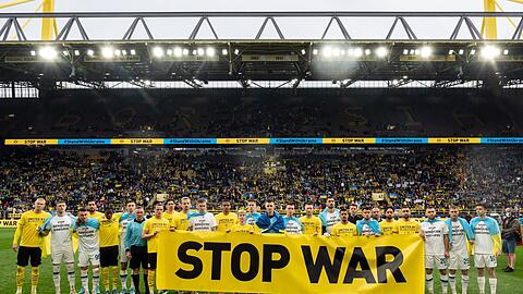 Vor dem Spiel geben beide Teams mit einem Banner ein Statement gegen den Krieg in der Ukraine ab.