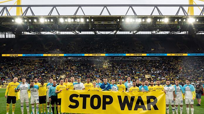 Vor dem Spiel geben beide Teams mit einem Banner ein Statement gegen den Krieg in der Ukraine ab.