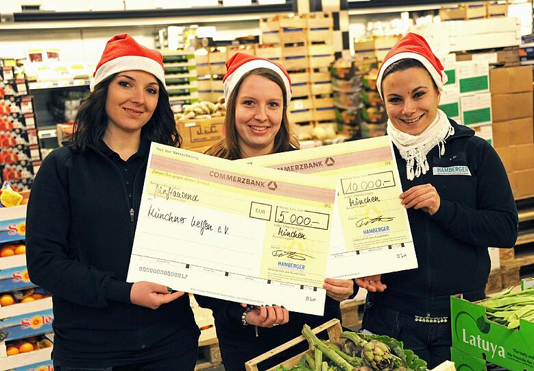 Zu dritt halten die Hamberger-Angestellten Katerina, Maria und Ayse die Spenden-Schecks.