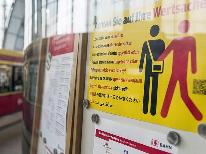 Ein Hinweisplakat warnt auf dem Bahnhof Alexanderplatz in mehreren Sprachen vor Taschendiebstahl.