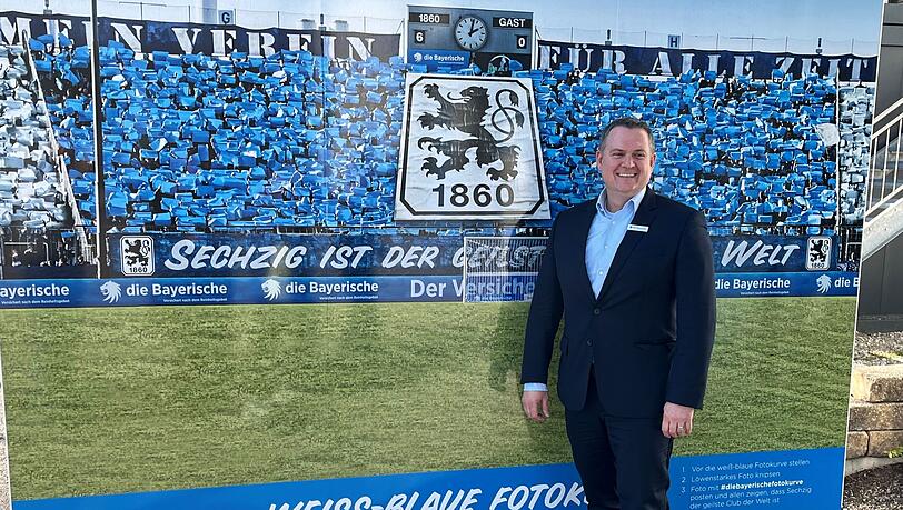Oliver Mueller, neuer Geschäftsführer des TSV 1860 München, steht vor eine Fotowand.