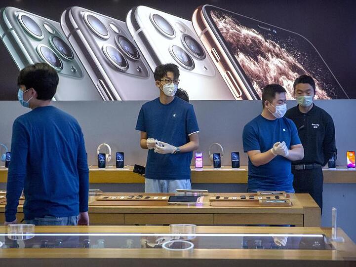 Dieser Apple-Store in Peking hat zwar wieder geöffnet, die Mitarbeiter schützen sich aber trotzdem weiter mit Mundschutz und Handschuhen.