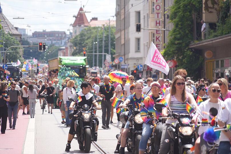 Mittendrin, statt nur dabei: Münchens OB Dieter Reiter ganz leger in Jeans, schwarzem T-Shirt, Sneakers und regenbogenfarbiger Blümchenkette. Rechts neben ihm Dominik Krause.