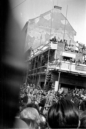 Rohbauten, Gerüste und Ruinen-Reste werden beim Trachtenumzug 1950 einfach in Zuschauer-Tribünen umgewidmet.
