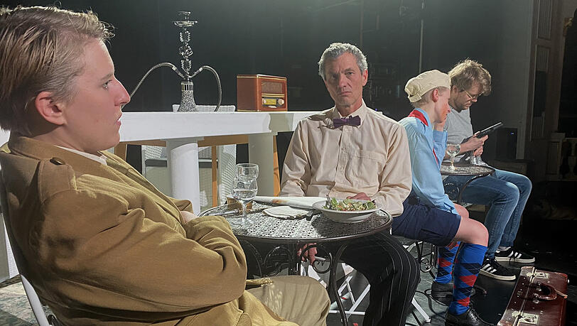 Giulio Cesare (Lena Spohn) hängt mit anderen Gästen in Rick's Café herum.