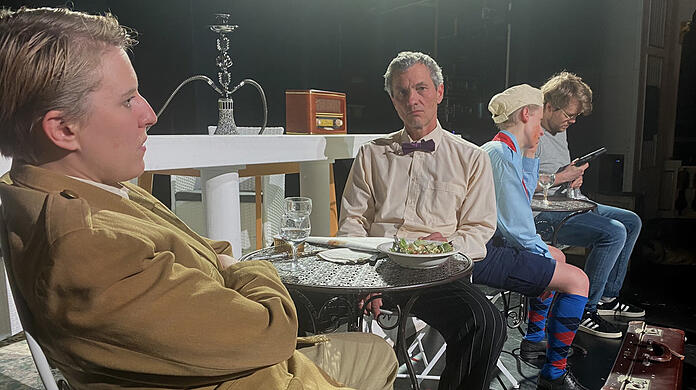 Giulio Cesare (Lena Spohn) hängt mit anderen Gästen in Rick's Café herum.
