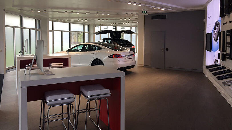 Im weltweit verbreiteten Tesla-Stil: Der neue Store in Grünwald, im Hintergrund zeigt ein Model X seine Flügeltüren.
