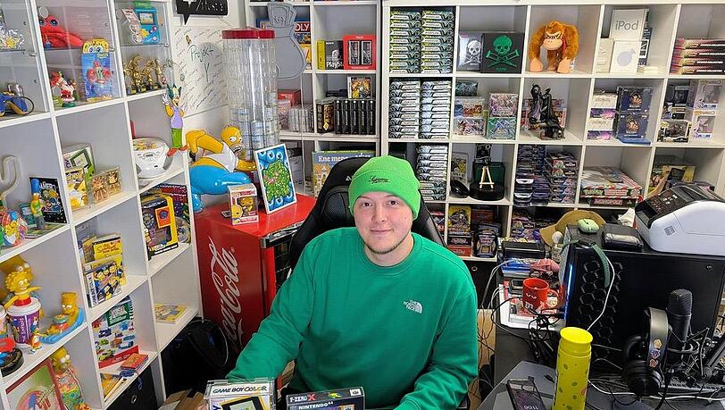 Jonas Steinbei&szlig;er in seinem B&uuml;ro, aus dem er Youtube-Videos postet &ndash; mit Tipps f&uuml;rs Schn&auml;ppchenjagen auf Flohm&auml;rkten. Die Spiele und Konsolen in seinen Regalen hat er auf seinen Streifz&uuml;gen gefunden.