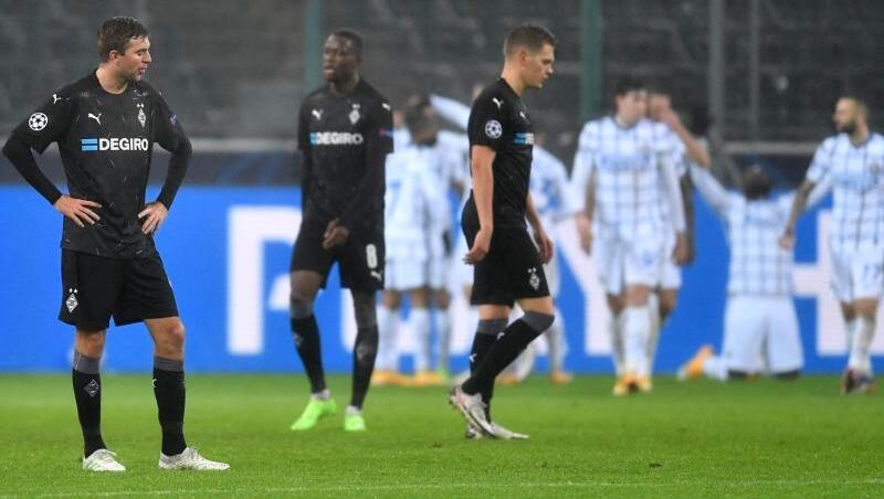 Mönchengladbachs Christoph Kramer (l-r), Denis Zakaria und Matthias Ginter stehen nach dem Gegentor zum 1:3 enttäuscht auf dem Rasen.