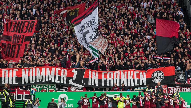 Die Nürnberger Spieler jubeln nach dem Abpfiff über ihren Sieg vor der Fankurve.
