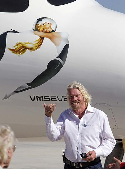 Während "Virgin Galactics"-Chef Branson vor seinem Raumschiff für die Fotografen posiert, winkt er stolz seiner Mutter Eve, die ebenfalls zur Eröffnung des Weltraumbahnhofs in die USA gereist ist.