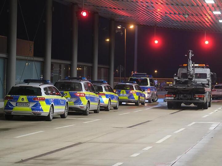 Ein Abschleppwagen steht an der Vorfeldschranke nahe Terminal A neben Polizeifahrzeugen.