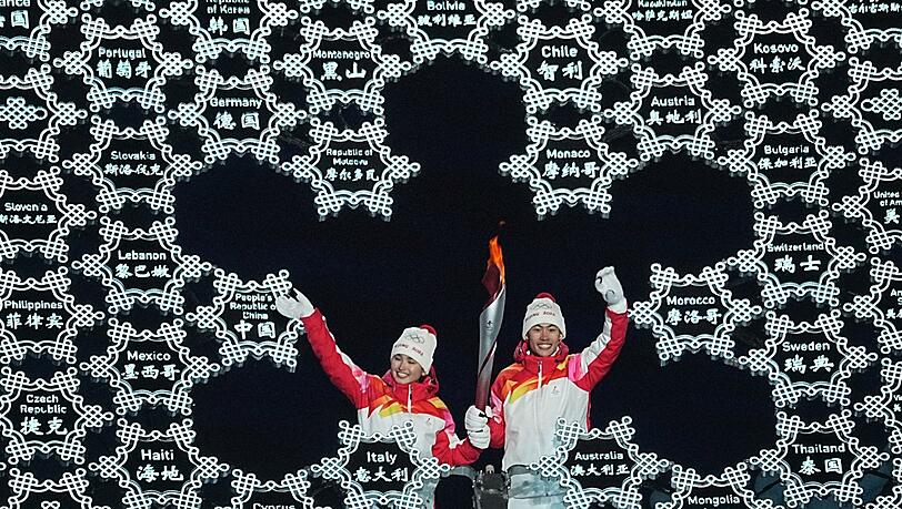 Chinas Zhao Jiawen (r) und Yilamujiang Dinigeer haben das olympische Feuer für die Winterspiele in Peking entzündet.