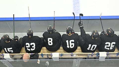 Spieler der deutschen Eishockey-Nationalmannschaft sitzen bei einer Trainingseinheit auf der Bank.