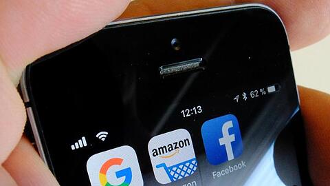 Logos der US-Internetkonzerne Google, Amazon und Facebook sind auf dem Display eines iPhones zu sehen.
