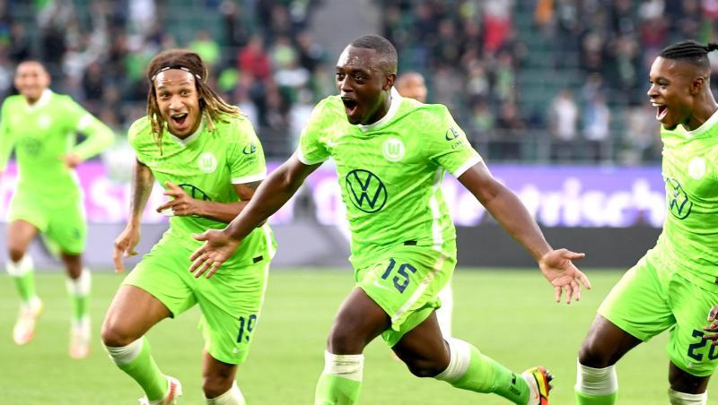 Wolfsburgs Jerome Roussillon (M) jubelt nach seinem Treffer zum 1:0 mit seinen Teamkollegen Kevin Mbabu (l) und Ridle Baku (r).
