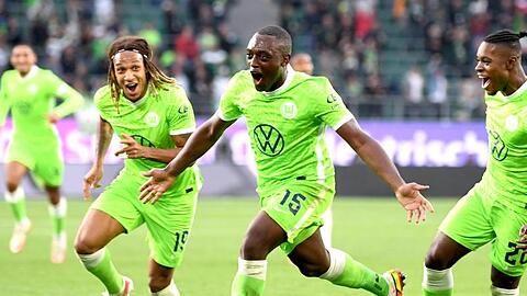 Wolfsburgs Jerome Roussillon (M) jubelt nach seinem Treffer zum 1:0 mit seinen Teamkollegen Kevin Mbabu (l) und Ridle Baku (r).